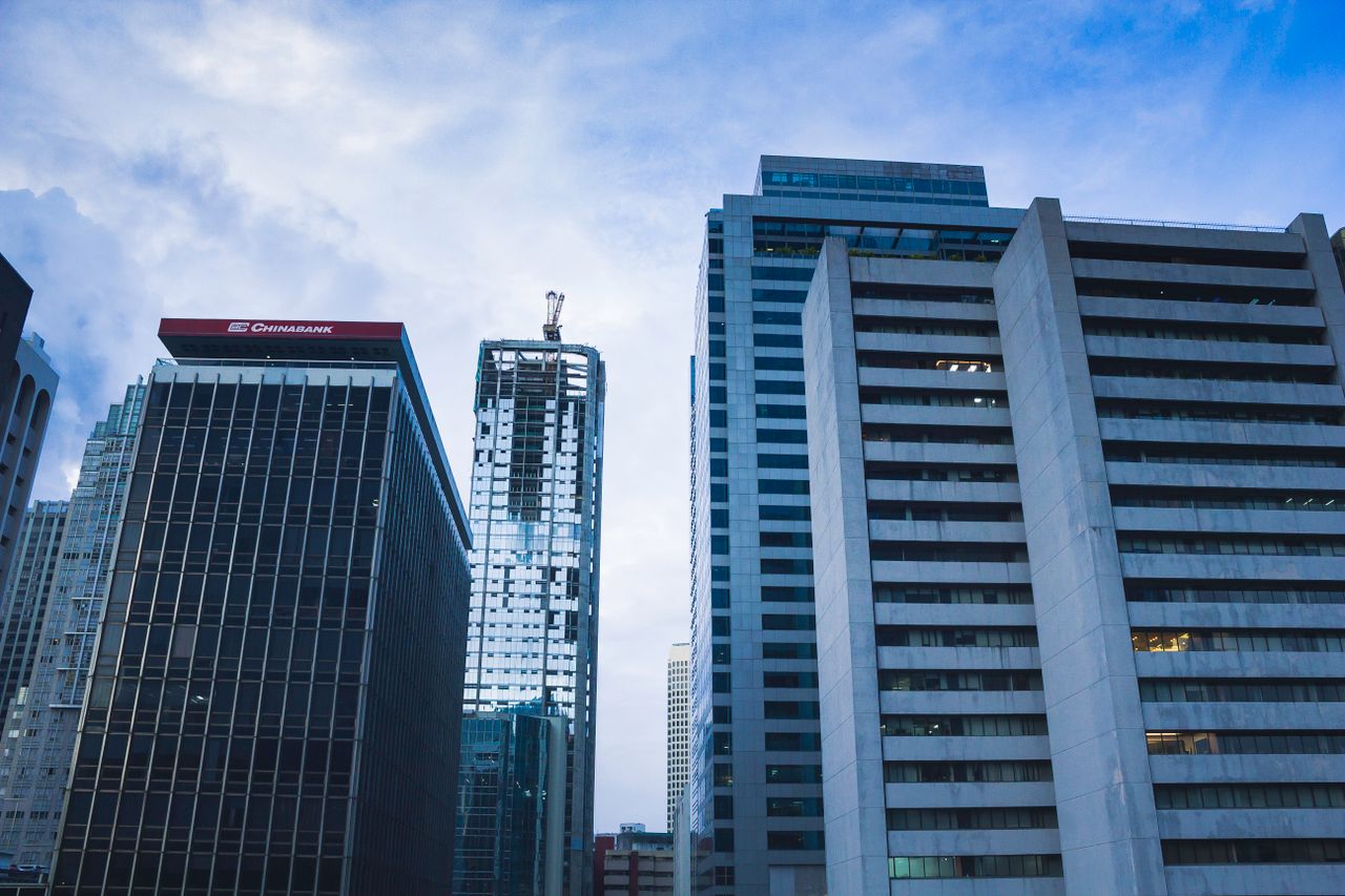 Tall skyscrapers dominate the urban skyline, showcasing modern architectural designs in twilight.