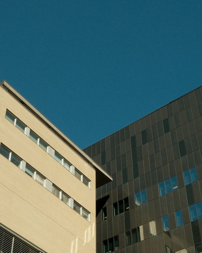 Services Low angle view of contemporary building facades against clear blue sky