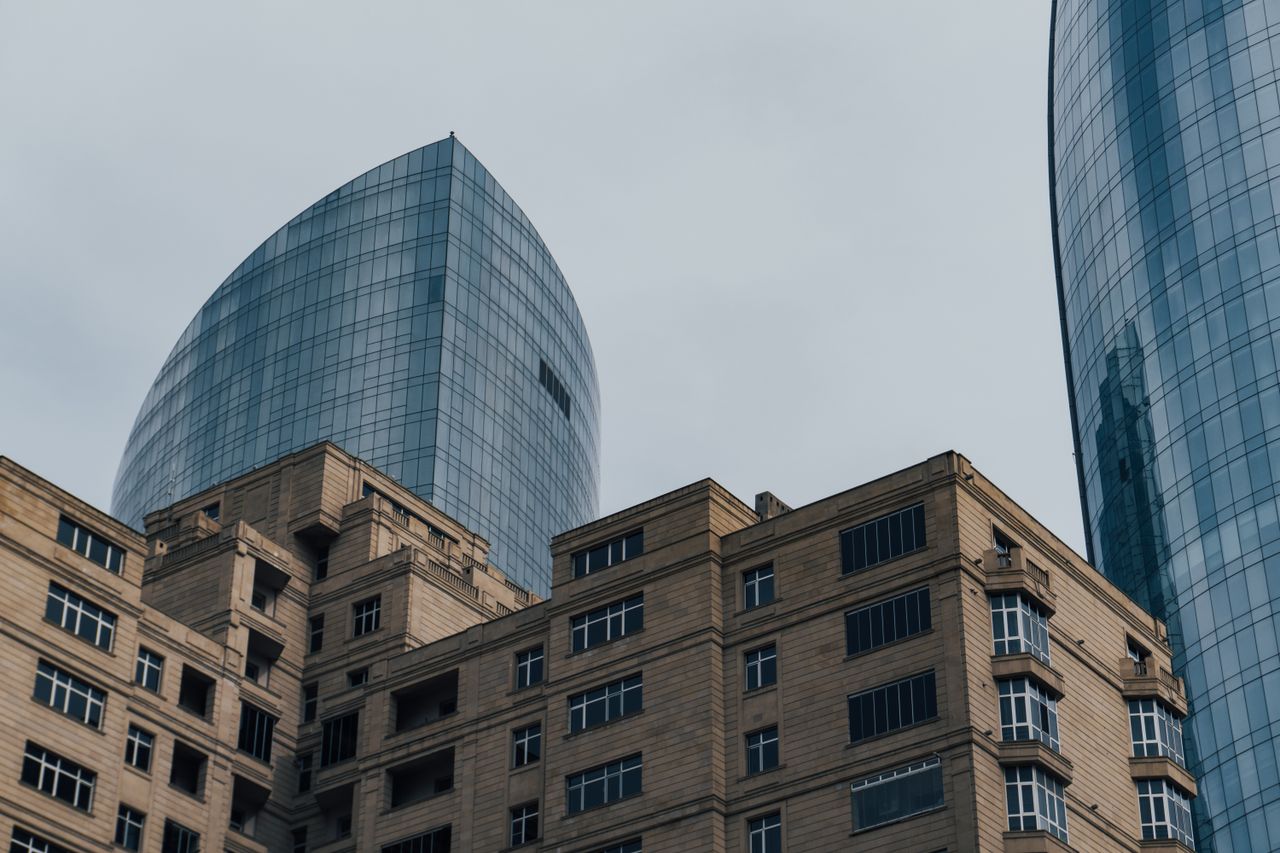 View of modern skyscrapers and classic building architecture in an urban setting.