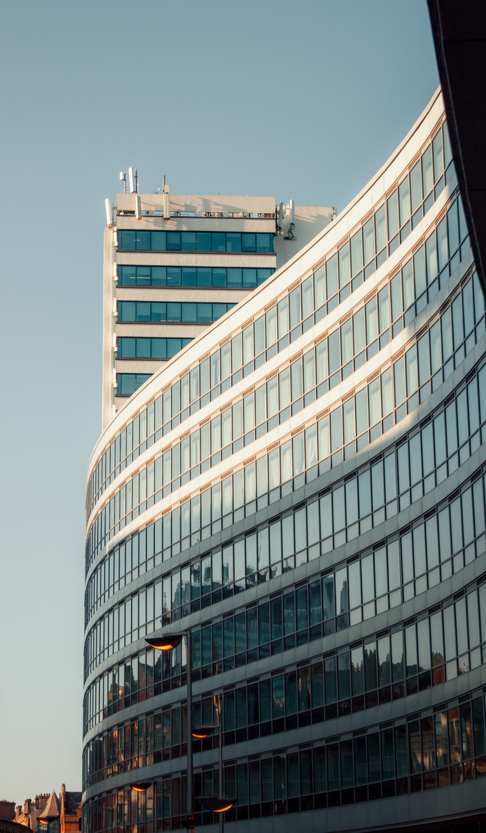 Services Curved glass skyscraper in Manchester, UK under a clear sky